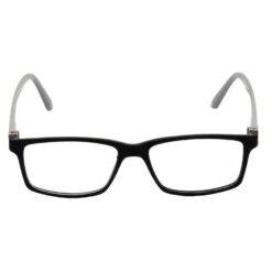 A shot from behind a computer monitor showing a person's focused face wearing glasses.