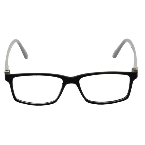 A shot from behind a computer monitor showing a person's focused face wearing glasses.